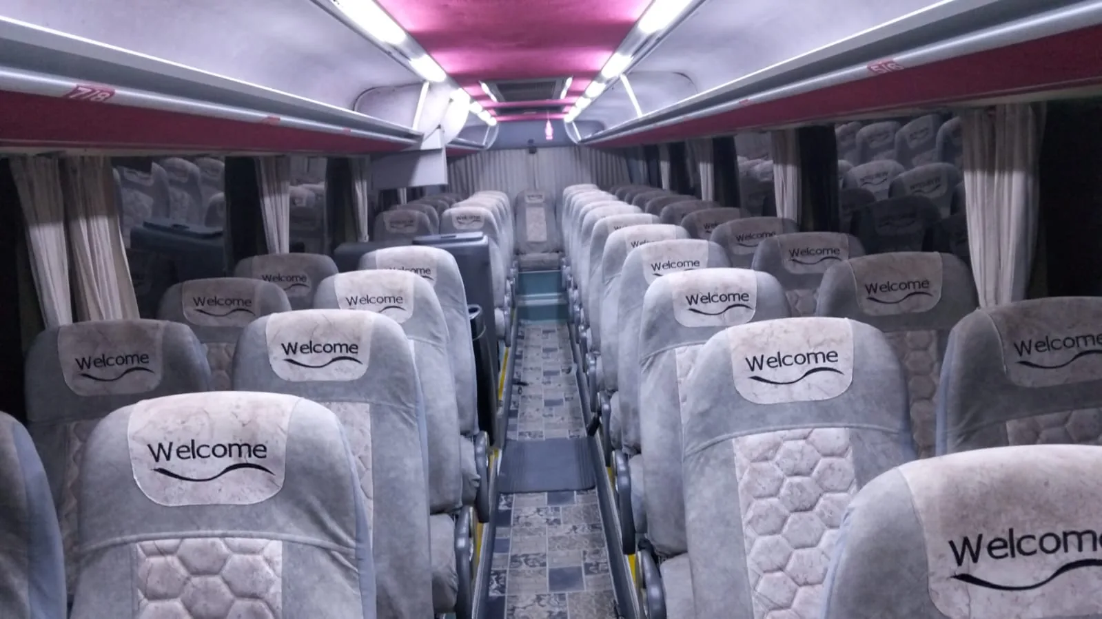 Seating rows and the central aisle inside a tourist coach.